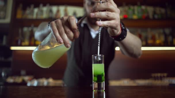 Barman w pracy w barze przygotowuje koktajl - kieliszek z absyntem. — Wideo stockowe