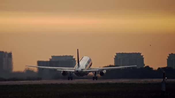 Samolot startuje w krajobrazie miasta o zachodzie słońca, wschodzie słońca. — Wideo stockowe