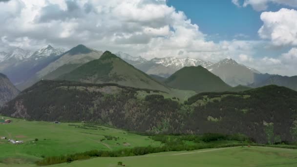 Klassiskt alpint landskap med berg, gröna kullar och snötoppar — Stockvideo
