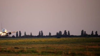 Gün batımında bir yolcu uçağının destansı inişi.