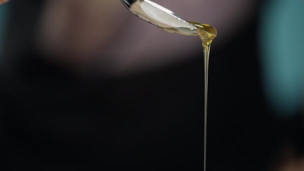 Close-up van een lepel waaruit honing wordt gegoten. — Stockvideo