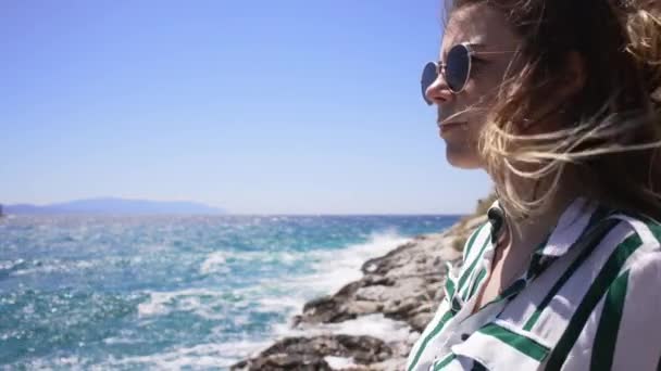 Портрет молодої жінки, що розвиває волосся біля моря . — стокове відео