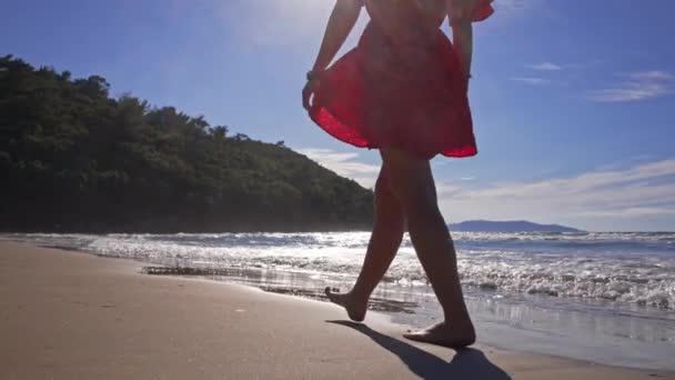 Vrouw op het strand die over het water loopt. — Stockvideo