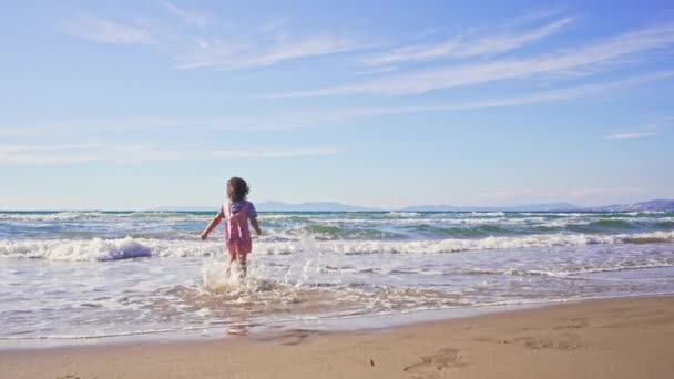 Meisje rennen in het zeewater, mooie zonnige dag. — Stockvideo