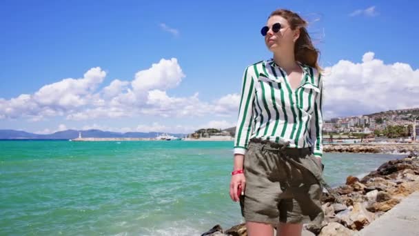 Vrouw in casual outfit en bril door de zee. — Stockvideo