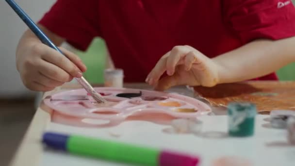 Çocuk fırçasını boyaya batırır.. — Stok video