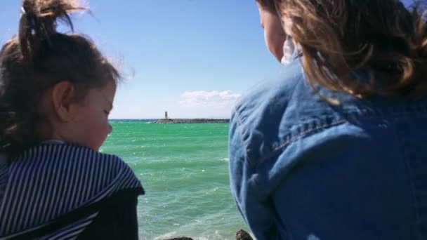 Twee kleine meisjes op de dijk kijken naar de zee. — Stockvideo