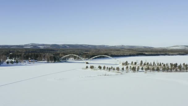 Letecký pohled na most přes řeku v lesích v zimě. — Stock video