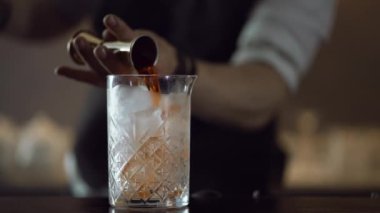 Barmen barda bir kokteyl hazırlıyor. Buza nar yağı döker.. 