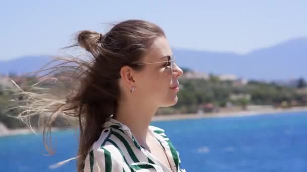 Vackert porträtt av en flicka i solglasögon tittar in i fjärran — Stockvideo