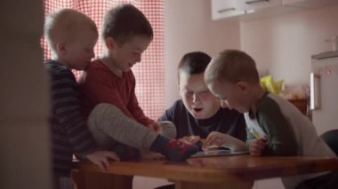 Bir grup çocuk tablet izliyor.