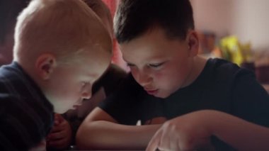 Çocuklar evde, masada akıllı telefon oyunları oynuyorlar.. 