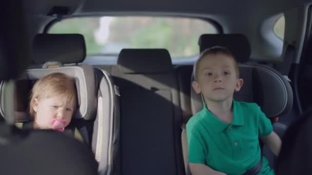 Los niños viajan en el coche, en sus asientos de coche para niños.. — Vídeo de stock