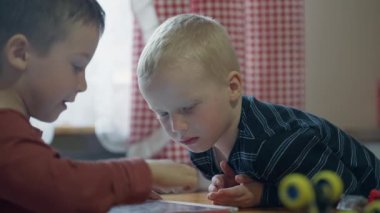 İki beyaz çocuk bir tablette oyun oynuyor.. 