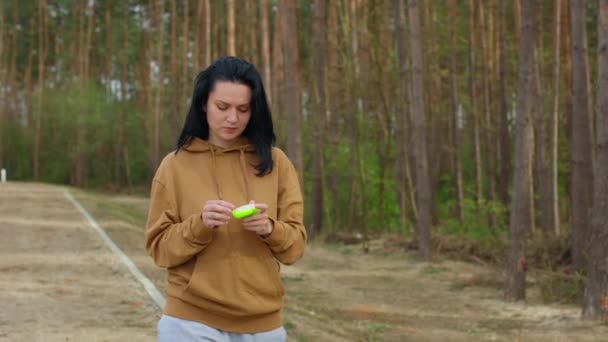 Woman puts on wireless headphones and runs. — Stock videók