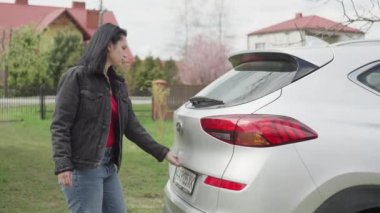 Woman picks up packages from the car.
