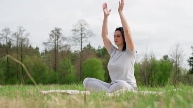 Doğayla baş başa bir kız yoga yapıyor..
