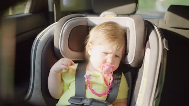 Menina caucasiana passeios em um assento de carro infantil. — Vídeo de Stock