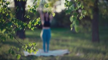 Genç beyaz kız doğada meditasyon yapıyor. Ağaçlar ve güzel manzarayla ormanda yoga yaparken tek başına aktif istirahat ve konsantrasyon..