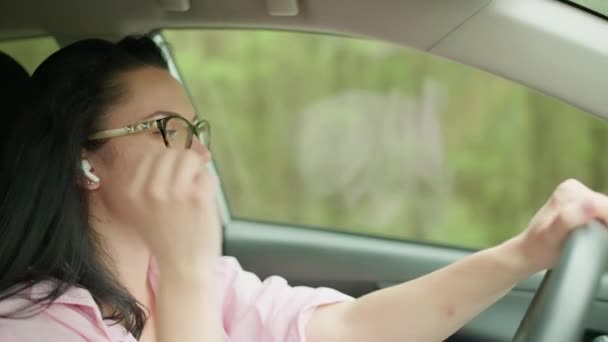 Menina Está Dirigindo Carro Coloca Fone Ouvido Menina Falando Telefone — Vídeo de Stock