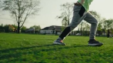 Mutlu çocuklar gün batımında futbol oynuyor. Takım oyunu bir çocuk futbol sahasında topa vuruyor ve gol atıyor..