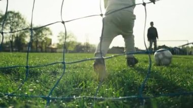 Çocuklar spor yapar ve futbol oynar. Çocuklar çimlerde topa vurur, mutlu çocuklar oyunu oynar..