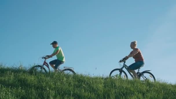 妇女和男孩在公园里骑自行车 家庭自行车在大自然中行驶 积极的休息和生活方式视频 — 图库视频影像