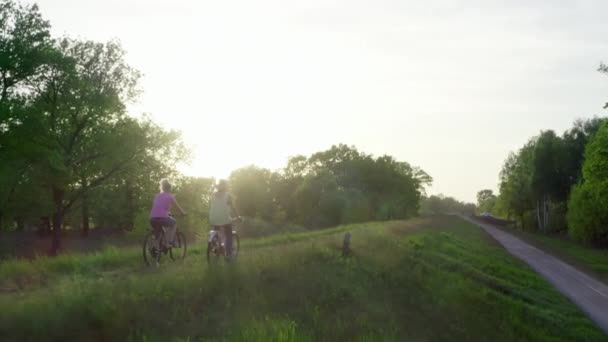 白人女朋友在公园里骑自行车 女子和两支队伍骑自行车在美丽的自然景观的路上 与朋友们一起积极地娱乐 — 图库视频影像