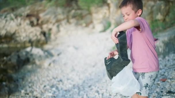 Мальчик Чистит Мусор Пляже Моря Ребенок Выбрасывает Пластиковые Отходы Мешок — стоковое видео