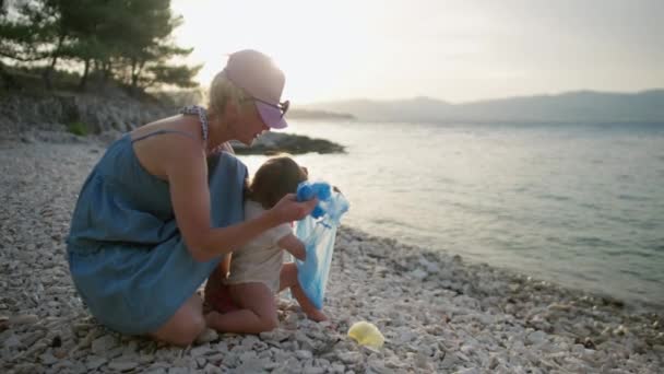 Mamma Bambino Puliscono Spiaggia Dalla Spazzatura Ragazza Getta Plastica Sacco — Video Stock