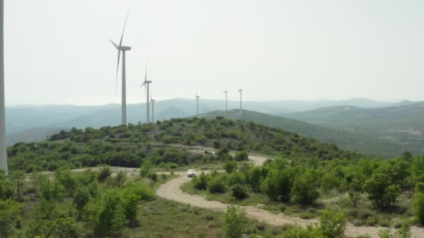 Coche Carretera Cerca Los Molinos Viento Las Montañas Producción Energía — Vídeo de stock