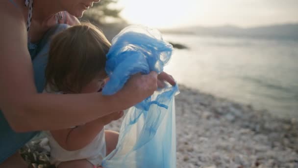 Niño Con Madre Recoge Basura Junto Océano Familia Limpia Playa — Vídeos de Stock