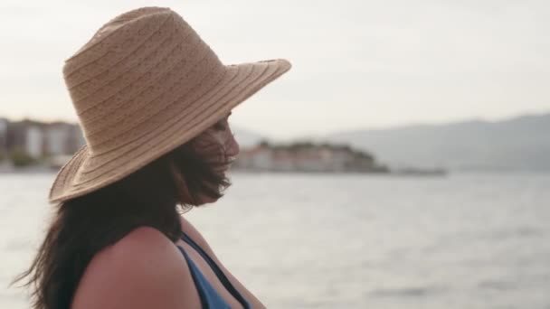 바다를 배경으로 여성의 사진입니다 모자를 소녀는 휴식을 취하고 바다를 일광욕을 — 비디오