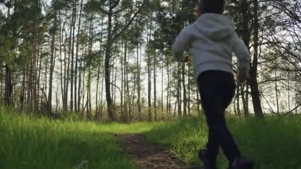 Chłopiec Biegnie Przez Las Zachodzie Słońca Powolny Film Szczęśliwym Uśmiechniętym — Wideo stockowe