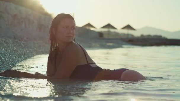 一个女孩躺在海滩上的延时录像 美丽的女人在日落时带着美丽的风景在海边度假 — 图库视频影像