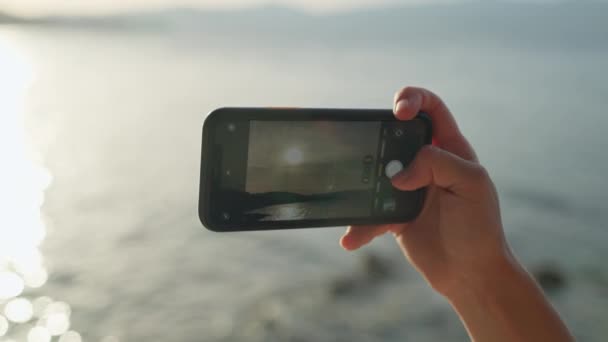 Telefonun Kadın Ellerinde Yakın Plan Çekimi Gün Batımında Deniz Kenarında — Stok video
