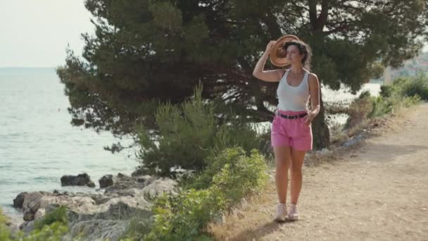 아름다운 소녀가 공원의 산책로를 다닌다 여행중 모자를 여자가 로맨틱하고 몽환적 — 비디오