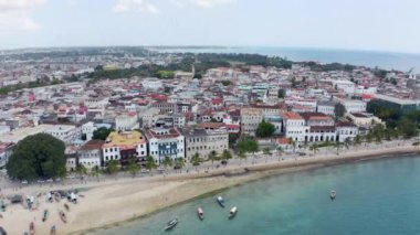 Taştan Kasaba 'nın sahil şeridinin insansız hava aracı videosunda Hint Okyanusu' ndaki eski sokak evlerinde duran tekneleri ve sahil şeridinde bir plajı ve güzel manzarayı görebilirsiniz. Hava Çekimi Zanzibar Tanzanya.