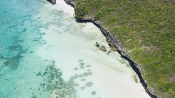 空中ビューザンジバルタンザニア 青い水とビーチでインド洋の海岸線に岩やサンゴ礁と海岸線を飛んでドローン — ストック動画