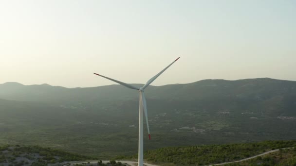 山の自然の風景の中に風車による電力生産の空中ビュー クリーンエネルギー産業と山脈とピーク — ストック動画