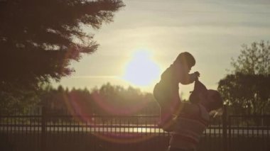 Ebeveynler çocukları sever, mutlu bir çocukluk. Genç bir annenin yavaş çekim videosu kızını bir kilometre taşına fırlatıyor.