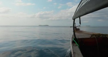 Hareket halindeki bir teknenin çerçevesi. Çapanın yattığı geminin pruvası Hint Okyanusu 'nun dalgalarında yüzer ve arka planda desenli gökyüzünü görebilirsiniz..