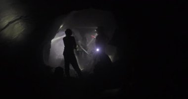 Madenciler, far ışığının yanıp söndüğü Tanzanit madeninin tünelinde çalışıyor. Mineral çıkarmanın güzel videosu.