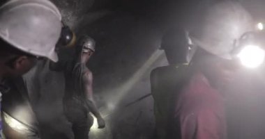 Tanzanit madencileri mineral çıkarmak için dinamit döşemek üzere kaya deliyorlar. Sıkı şapkalı güzel insanlar çalışıyor..