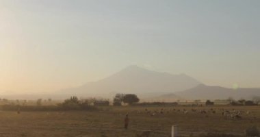 Afrika 'da geleneksel bir köy olan Savannah' ı, ağaçları, güzel manzarayı ve gün batımında dağların arka planında gündoğumunu gösteren bir video..