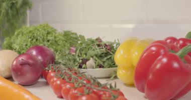 Taze sebzeler mutfak masasında duruyor. Biber, patates, soğan, salata, domates ve sebzeli organik ve sağlıklı yiyecekler mutfakta pişirmeye hazır, makro video 4K yavaş çekim.