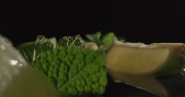 Soğutucu kokteyller yapmak için gerekli malzemeler. Limonata ya da mojito içeceklerine taze organik limon ve nane eklenmeye hazır. 4K sinematik video.
