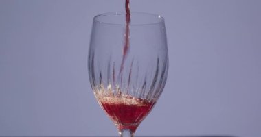 Taze doğal alkollü içecek şarabı. Şişeden bardağa kırmızı şarap döküyorum. 4K yavaş çekim videosunda yakın çekim.