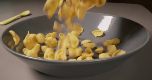 早餐麦片健康食品在厨房里 早上煮好吃的新鲜玉米片 然后倒入盘子里 慢镜头4K — 图库视频影像