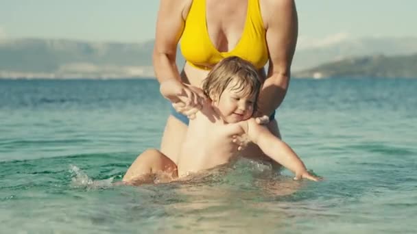 Spowolniony Film Dzieckiem Ramionach Matki Pluskającej Się Morzu Uśmiechnięta Dziewczyna — Wideo stockowe
